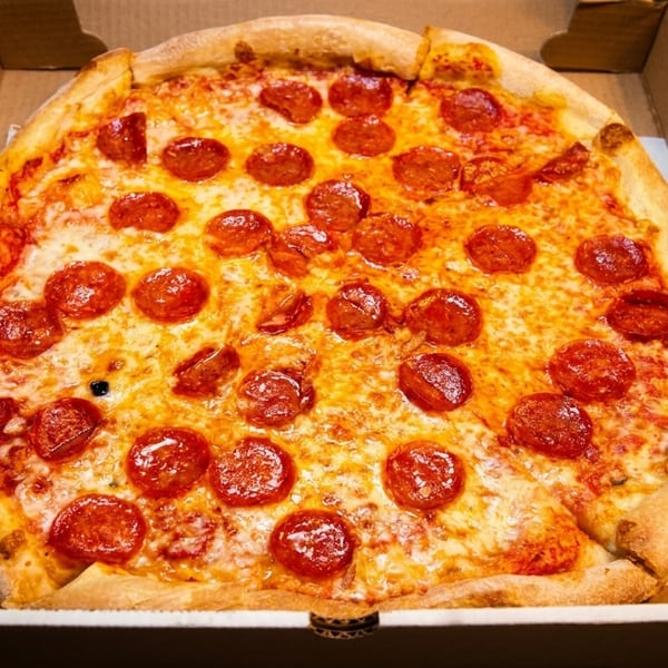 A freshly baked pepperoni pizza, generously topped with cheese, sits in an open cardboard box.